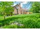 Serene backyard showcasing a brick home, mature trees, and lush greenery, creating a private oasis at 5851 Beisinger Pl, Indianapolis, IN 46237