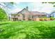 Spacious backyard with lush lawn, mature trees, and a brick home exterior, creating a picturesque setting at 5851 Beisinger Pl, Indianapolis, IN 46237