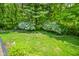 Lush backyard with mature trees and flowering bushes creating a serene outdoor space at 5851 Beisinger Pl, Indianapolis, IN 46237