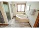 Bathroom featuring a large soaking tub next to a large window and glass door shower at 5851 Beisinger Pl, Indianapolis, IN 46237
