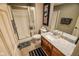 Updated bathroom features a glass enclosed shower, wooden vanity and framed Hollywood movie poster at 5851 Beisinger Pl, Indianapolis, IN 46237