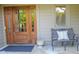 Inviting front porch with a wooden door, a bench, and a decorative pillow at 5851 Beisinger Pl, Indianapolis, IN 46237