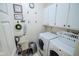 Well-organized laundry room with modern washer, dryer, utility sink, and ample storage at 5851 Beisinger Pl, Indianapolis, IN 46237