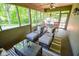 Cozy screened porch with wicker furniture, plush cushions, and a glass-top table, perfect for relaxing at 5851 Beisinger Pl, Indianapolis, IN 46237