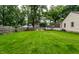 Spacious backyard with lush green grass, wooden fence, shed and a firepit surrounded by chairs at 6137 Evanston Ave, Indianapolis, IN 46220