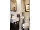 Modern powder room featuring a floating sink, squared mirror and toilet at 6137 Evanston Ave, Indianapolis, IN 46220