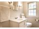 Bright bathroom featuring a white vanity, a mirror and a toilet under the window at 6137 Evanston Ave, Indianapolis, IN 46220