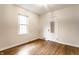 Bright bedroom with hardwood floors, a window with blinds and white door with mirror at 6137 Evanston Ave, Indianapolis, IN 46220