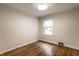 A bright and airy bedroom boasts pristine hardwood floors and ample natural light from a large window at 6137 Evanston Ave, Indianapolis, IN 46220