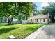 Quaint home featuring a lush lawn, stone facade, and inviting pathway leading to the front door at 6137 Evanston Ave, Indianapolis, IN 46220
