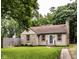 Charming single-story home featuring stone accents, a well-manicured lawn, and a cozy entryway at 6137 Evanston Ave, Indianapolis, IN 46220