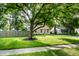 Well-maintained lawn with mature tree and lush foliage provides shade and beauty at 6137 Evanston Ave, Indianapolis, IN 46220
