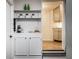 Hallway featuring a white shelf, wine bottles, and a view into the marble counter topped kitchen at 6137 Evanston Ave, Indianapolis, IN 46220