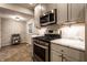 Galley kitchen boasts stainless steel appliances, marble countertops, and an eye-catching brick accent wall at 6137 Evanston Ave, Indianapolis, IN 46220