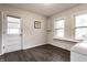 Laundry room with dark vinyl floors, a window, and back door at 6137 Evanston Ave, Indianapolis, IN 46220