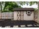 The storage shed has a white exterior, dark brown trim, and a single window at 6137 Evanston Ave, Indianapolis, IN 46220