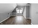 An attic with gray walls, wood flooring, natural lighting, and simple storage at 6159 Broadway St, Indianapolis, IN 46220