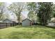 View of backyard featuring well maintained yard, garage, and privacy fence at 6159 Broadway St, Indianapolis, IN 46220