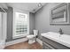 Bathroom featuring neutral tile, gray vanity, and glass block window at 6159 Broadway St, Indianapolis, IN 46220