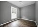 A standard bedroom design with gray walls, wood flooring, and a well-lit window at 6159 Broadway St, Indianapolis, IN 46220