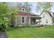 Classic home featuring a covered porch and well-maintained lawn with mature trees at 6159 Broadway St, Indianapolis, IN 46220