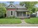 Charming craftsman-style home with a covered front porch and lush landscaping at 6159 Broadway St, Indianapolis, IN 46220