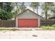 View of the home's detached garage with red door at 6159 Broadway St, Indianapolis, IN 46220