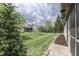 View of backyard with mature trees, a screened-in porch, and well-maintained lawn, creating a serene outdoor space at 6503 E Walton Dr, Camby, IN 46113