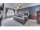 Main bedroom featuring a king-size bed, soft carpet, ceiling fan, and natural light at 6503 E Walton Dr, Camby, IN 46113