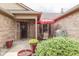 Inviting front porch area with a red umbrella, potted plants, and outdoor seating, perfect for relaxing at 6503 E Walton Dr, Camby, IN 46113