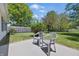 Cozy backyard with a patio, green grass, chairs, and surrounding trees on a sunny day at 6613 Apollo Way, Indianapolis, IN 46278