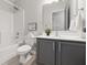 Clean bathroom featuring a shower/tub combo, gray vanity, and a modern white toilet at 6613 Apollo Way, Indianapolis, IN 46278