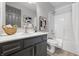 Bright bathroom features a gray vanity with a white countertop, a framed mirror, and a shower-tub combination at 6613 Apollo Way, Indianapolis, IN 46278