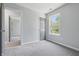 Neutral bedroom with gray carpet, gray trim, a window with natural light, and a door to an adjoining room at 6613 Apollo Way, Indianapolis, IN 46278