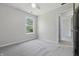 Bedroom with gray carpet, ceiling fan, view from window, and door to adjoining room at 6613 Apollo Way, Indianapolis, IN 46278