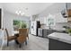 Modern kitchen with white cabinets, stainless steel appliances, and a dining area with wicker chairs at 6613 Apollo Way, Indianapolis, IN 46278