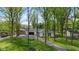 Aerial view of a charming home surrounded by lush trees and a well-manicured front yard at 6673 Karyn Dr, Avon, IN 46123
