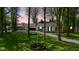Charming single-story home featuring a two-car garage and well-manicured front lawn at dusk with American flag at 6673 Karyn Dr, Avon, IN 46123