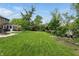 Spacious backyard with lush green grass, mature trees, and a charming shed, offering a serene outdoor retreat at 6825 Farmleigh Dr, Indianapolis, IN 46220