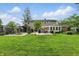 Large backyard featuring a well-maintained lawn, pergola, sunshade, and lush landscaping, creating an inviting outdoor oasis at 6825 Farmleigh Dr, Indianapolis, IN 46220
