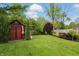 Spacious backyard featuring a well-maintained lawn, storage shed, and lush landscaping at 6825 Farmleigh Dr, Indianapolis, IN 46220