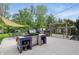 Inviting backyard featuring an outdoor kitchen, dining area, shade structure and lush greenery, perfect for enjoying the outdoors at 6825 Farmleigh Dr, Indianapolis, IN 46220