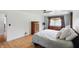 Bright bedroom featuring hardwood floors, ceiling fan and large windows with wooden dresser in view at 6825 Farmleigh Dr, Indianapolis, IN 46220