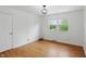 Bright bedroom with natural light, hardwood floors, and a modern ceiling light fixture at 6825 Farmleigh Dr, Indianapolis, IN 46220