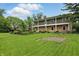 Spacious home with a large green lawn and mature trees on a sunny day at 6825 Farmleigh Dr, Indianapolis, IN 46220