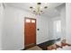 Bright foyer with hardwood floors, white walls, stairs, and an painted front door at 6825 Farmleigh Dr, Indianapolis, IN 46220