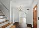 Entryway featuring hardwood floors, staircase, chandelier, and painted front door at 6825 Farmleigh Dr, Indianapolis, IN 46220