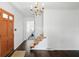 Inviting foyer with hardwood floors, staircase, chandelier, and painted entry door at 6825 Farmleigh Dr, Indianapolis, IN 46220