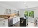 Bright kitchen with white cabinetry, stainless steel appliances, and outdoor access at 6825 Farmleigh Dr, Indianapolis, IN 46220