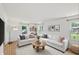 Bright living room with hardwood floors, white walls, couches, and decorative pillows at 6825 Farmleigh Dr, Indianapolis, IN 46220